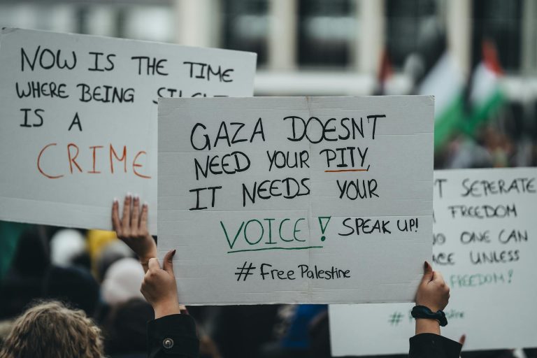 A crowd holding signs during a demonstration advocating for Gaza's freedom and voice. #FreePalestine
