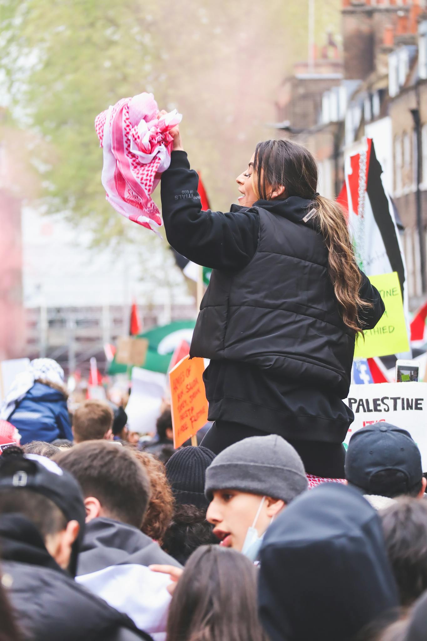 A lively protest featuring diverse activists with flags and placards in a city street.